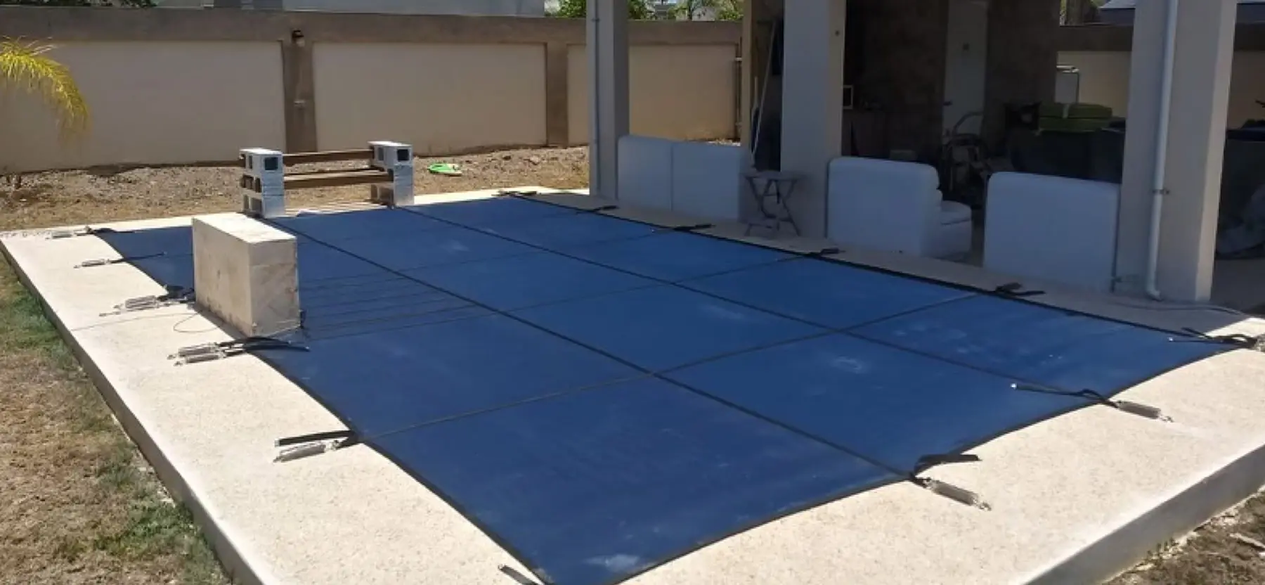 A rectangular pool with blue safety cover.